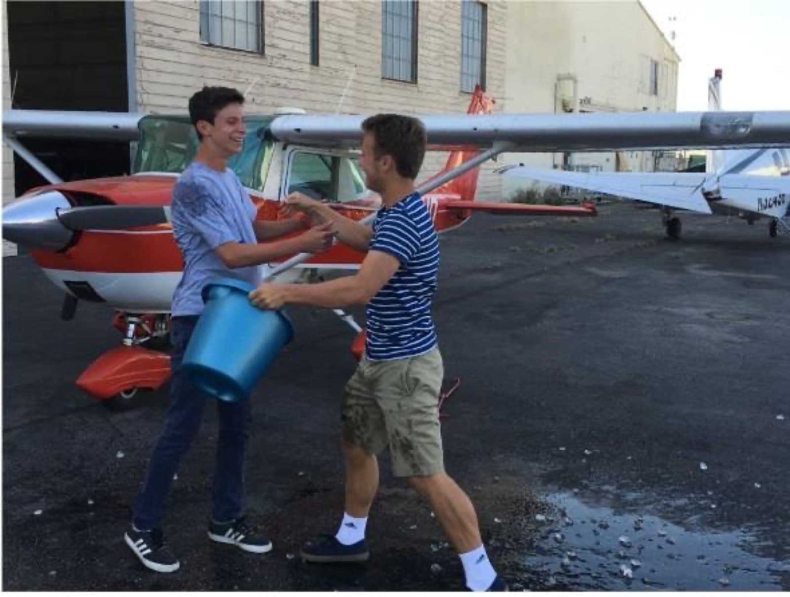 Alec beside a small airplane during flight training