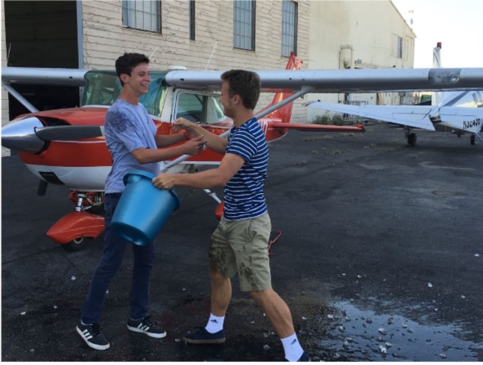 Alec standing beside a small airplane during flight training
